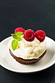 Cupcake with cream cheese topping and fresh raspberries