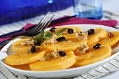 Persimmon kaki (sharon fruit) slices with raisins, walnuts and syrup