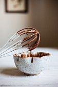 Honey Cocoa Glaze Dripping from a Whisk