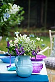 Sommerlicher Blumenstrauss auf gedecktem Tisch im Freien