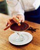 Chocolate dessert being garnished with a lychee