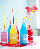 Bottles of coloured soft drinks with name labels for a child's birthday