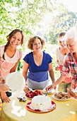 Vier Frauen bei einer Gartenparty mit Kuchen und Erdbeeren