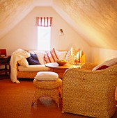 Cosy attic room with basketwork seating and striped Roman blind on narrow gable window