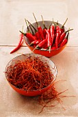 Chilli strands and fresh whole chillies in bowls