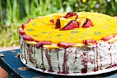 A colourful cream layer cake for a birthday, with assorted fruits