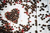Red and black peppercorns in the shape of a heart