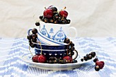 Blackcurrants and cherries in stacked teacups
