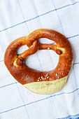 A lye pretzel on a tea towel (seen from above)
