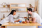 Young couple leaning on kitchen island