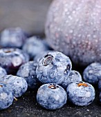 Blueberries with water droplets in front of a fig