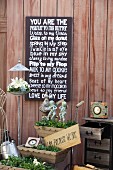 Wedding mottoes written on slate chalkboard above vintage, planted troughs