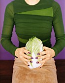 A woman holding a Chinese cabbage
