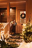 Weihnachtlich geschmückter Hauseingang mit Tannenzweigen, Türkranz & Tannenbaum