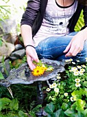 Teenage girl by a birdbath in a garden, Sweden.