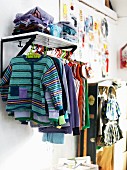 Garderobe in Kinderzimmer mit daran hängender Kinderkleidung
