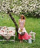 Portrait of woman holding basket above blossoming tree