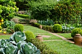 Gepflegte Nutzgartenanlage mit Rasenfläche und angeordneten Steinplatten