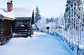 Scandinavian log cabin in snowy winter landscape