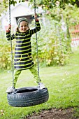 Girl on tyre swing in garden