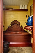 Outhouse with carved wooden privy and blue enamel pitcher and basin