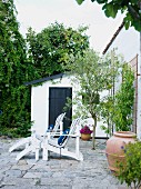 Two garden loungers on terrace adjoining house