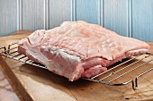 Raw pork belly on a grill rack