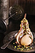 Poached pear with chocolate sauce and pistachios