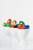 Colourful chocolate eggs in eggcups