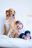 Little girl and dog on white couch