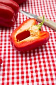 Rote Paprika auf kariertem Tischtuch, Messer
