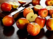 Several Braeburn apples, whole and halved