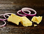 Cheddar and red onions on a wooden surface