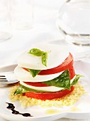 A Stacked Tomato Mozzarella and Basil Caprese Salad on a Parmesan Crisp