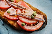 Crostini with tomatoes, anchovies and capers