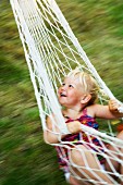 A happy girl swinging in a hammock.