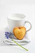 A cup of milk with a madeleine heart