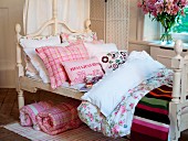 Nostalgic girl's bed with scatter cushions & blankets