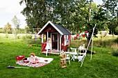 Mädchen spielt mit Spielhaus im Garten