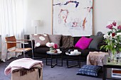 Modernes Wohnzimmer mit Sofa, Beistelltischchen, Lederstuhl & Wandgemälde
