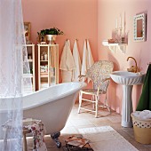 Romatisch eingerichtetes Badezimmer mit rosafarbenen Wänden & freistehender Badewanne