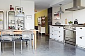 Lange Küchenzeile mit Schubladenschränken und Edelstahlfronten in offenem Wohnraum