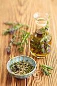 Olive oil with hyssop, and fresh hyssop on a wooden surface