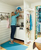Woman in small kitchen of Swedish holiday home