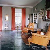 Living room with leather armchairs & antlers next to open fireplace