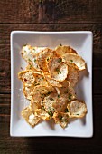 Oven Roasted Celeriac Chips on a White Plate