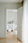 View into elegant, white living area with sideboard and seating group