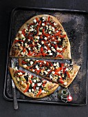 A lentil pizza with grilled peppers and sheep's cheese