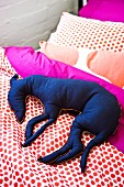 Blue fabric dog on polka-dotted bed linen