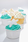 Cupcakes decorated with green and yellow frosting and snowflakes